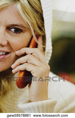 Stock Image - Portrait of a young woman talking on a mobile phone. Fotosearch