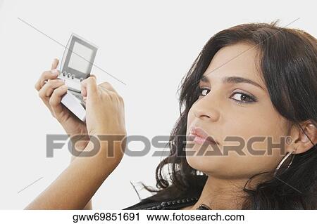 Portrait of a young woman using a calculator View Large Photo Image Stock Image - Portrait of a young woman using a calculator. Fotosearch