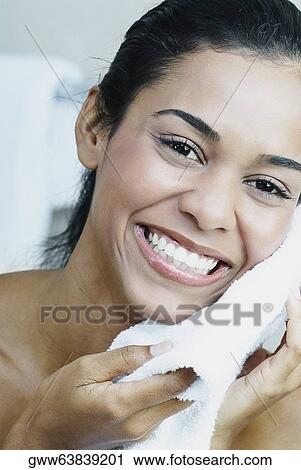Portrait of a young woman wiping her face with a towel View Large Photo Image Stock Image - Portrait of a young woman wiping her face with a towel. Fotosearch