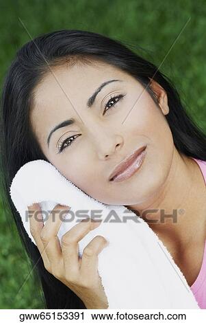 Portrait of a young woman wiping her face View Large Photo Image Stock Image - Portrait of a young woman wiping her face. Fotosearch