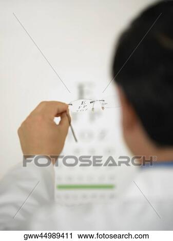 Stock Image - Rear view of a doctor holding a pair of eyeglasses. Fotosearch