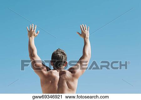 Rear view of a mid adult man standing with his arms raised View Large Photo Image Stock Image - Rear view of a mid adult man standing with his arms raised. Fotosearch