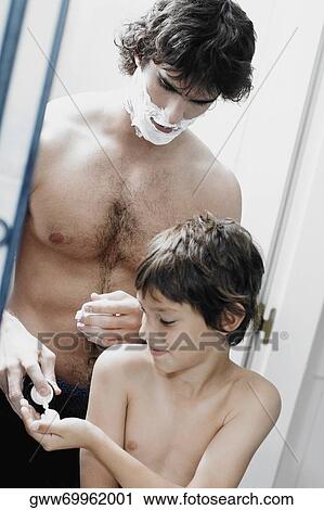 Reflection of a young man pouring shaving cream on his son's palm View Large Photo Image Stock Image - Reflection of a young man pouring shaving cream on his son's palm. Fotosearch