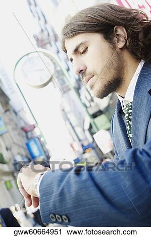 Side profile of a businessman checking the time View Large Photo Image Stock Image - Side profile of a businessman checking the time. Fotosearch