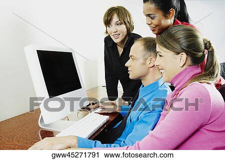 Side profile of a businessman with three businesswomen using a desktop PC View Large Photo Image Stock Image - Side profile of a businessman with three businesswomen using a desktop PC. Fotosearch