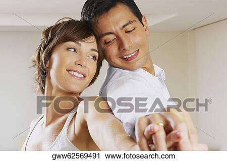 Side profile of a couple back to back and smiling View Large Photo Image Stock Image - Side profile of a couple back to back and smiling. Fotosearch