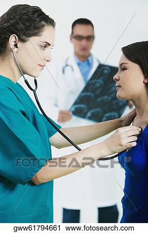 Side profile of a female doctor examining a girl with a stethoscope View Large Photo Image Stock Image - Side profile of a female doctor examining a girl with a stethoscope. Fotosearch