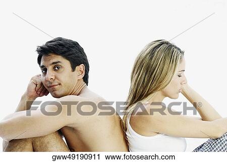Side profile of a mid adult couple sitting back to back and looking serious View Large Photo Image Stock Image - Side profile of a mid adult couple sitting back to back and looking serious. Fotosearch