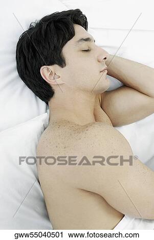 Stock Image - Side profile of a mid adult man sleeping on the bed. Fotosearch