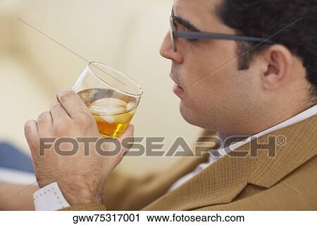 Side profile of a mid adult man drinking a glass of whiskey View Large Photo Image Stock Image - Side profile of a mid adult man drinking a glass of whiskey. Fotosearch