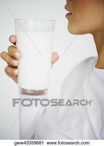 Side profile of a woman holding a glass of milk View Large Photo Image Stock Image - Side profile of a woman holding a glass of milk. Fotosearch