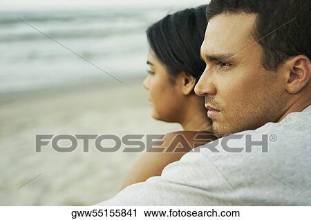 Side profile of a young couple sitting on the beach View Large Photo Image Stock Image - Side profile of a young couple sitting on the beach. Fotosearch