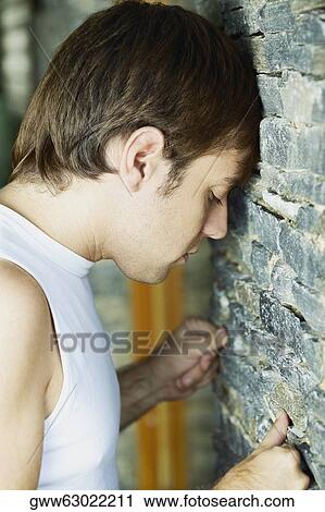 Side profile of a young man banging his head against a wall View Large Photo Image Stock Image - Side profile of a young man banging his head against a wall. Fotosearch