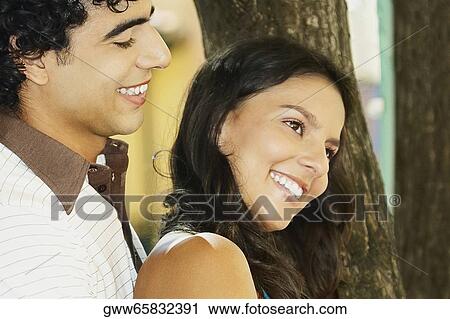 Side profile of a young man embracing a teenage girl from behind View Large Photo Image Stock Image - Side profile of a young man embracing a teenage girl from behind. Fotosearch