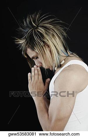 Side profile of a young man in a praying position View Large Photo Image Stock Image - Side profile of a young man in a praying position. Fotosearch