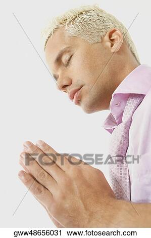 Side profile of a young man praying View Large Photo Image Stock Image - Side profile of a young man praying. Fotosearch