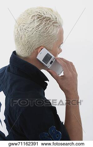 Side profile of a young man using a mobile phone View Large Photo Image Stock Image - Side profile of a young man using a mobile phone. Fotosearch