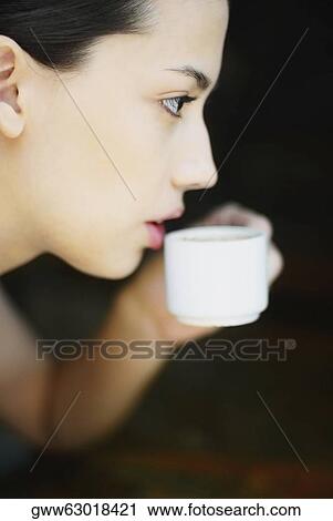 Side profile of a young woman holding a cup View Large Photo Image Stock Image - Side profile of a young woman holding a cup. Fotosearch