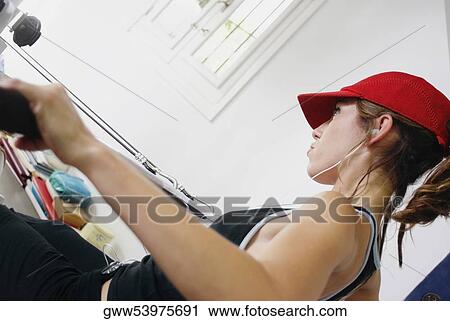 Side profile of a young woman exercising in a gym View Large Photo Image Stock Image - Side profile of a young woman exercising in a gym. Fotosearch