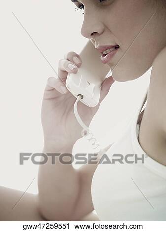 Side profile of a young woman using a telephone View Large Photo Image Stock Image - Side profile of a young woman using a telephone. Fotosearch