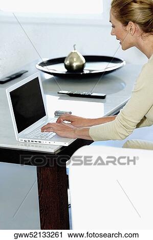 Side profile of a young woman using a laptop View Large Photo Image Stock Image - Side profile of a young woman using a laptop. Fotosearch