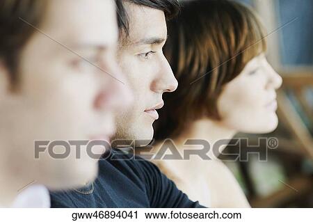 Side profile of two young men and a young woman View Large Photo Image Stock Image - Side profile of two young men and a young woman. Fotosearch