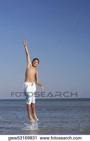 Teenage boy jumping in the sea View Large Photo Image Stock Image - Teenage boy jumping in the sea. Fotosearch