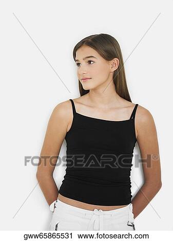 Teenage girl standing with her hands behind her back View Large Photo Image Stock Image - Teenage girl standing with her hands behind her back. Fotosearch