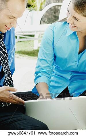 Teenage girl using a laptop with a businessman sitting beside her View Large Photo Image Stock Image - Teenage girl using a laptop with a businessman sitting beside her. Fotosearch
