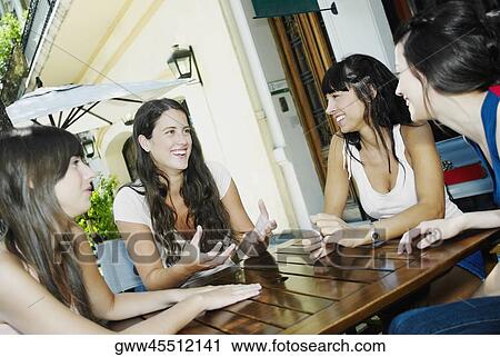 Two young women and two mid adult women smiling and sitting together View Large Photo Image Stock Image - Two young women and two mid adult women smiling and sitting together. Fotosearch