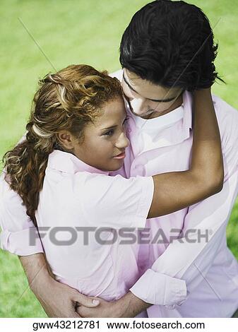 Young couple embracing each other View Large Photo Image Stock Image - Young couple embracing each other. Fotosearch
