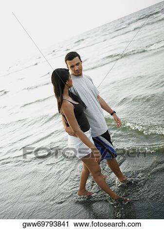 Young couple walking on the beach View Large Photo Image Stock Image - Young couple walking on the beach. Fotosearch
