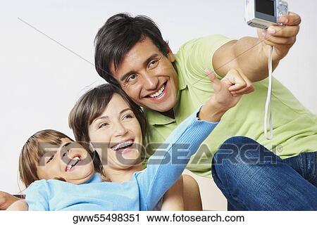 Young couple with their daughter taking a photograph of themselves View Large Photo Image Stock Image - Young couple with their daughter taking a photograph of themselves. Fotosearch