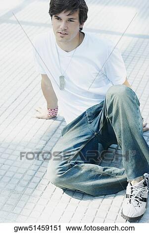 Stock Image - Young man sitting on the floor. Fotosearch