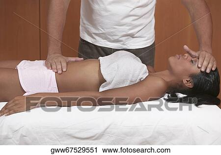 Young woman getting a massage from a massage therapist View Large Photo Image Stock Image - Young woman getting a massage from a massage therapist. Fotosearch