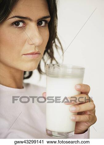 Young woman holding a glass of milk View Large Photo Image Stock Image - Young woman holding a glass of milk. Fotosearch