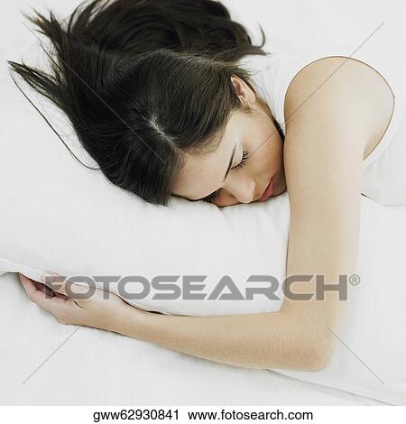 Young woman hugging a pillow on the bed and sleeping View Large Photo Image Stock Image - Young woman hugging a pillow on the bed and sleeping. Fotosearch