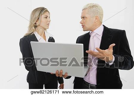 Businesswoman and a businessman using a laptop View Large Photo Image Stock Image - Businesswoman and a businessman using a laptop. Fotosearch