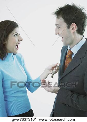Businesswoman giving keys to a businessman View Large Photo Image Stock Image - Businesswoman giving keys to a businessman. Fotosearch