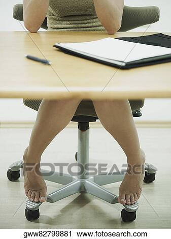 Stock Image - Businesswoman sitting at a table. Fotosearch