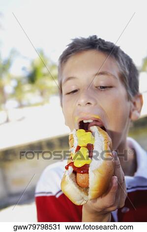 Close-up of a boy eating a hot dog View Large Photo Image Stock Image - Close-up of a boy eating a hot dog. Fotosearch