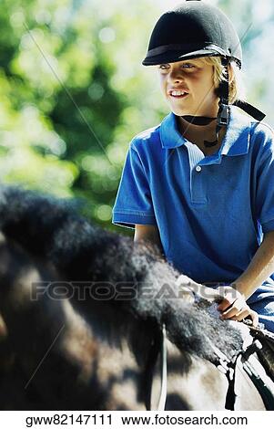 Close-up of a boy horseback riding View Large Photo Image Stock Image - Close-up of a boy horseback riding. Fotosearch