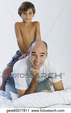 Close-up of a boy riding piggyback on his father View Large Photo Image Stock Image - Close-up of a boy riding piggyback on his father. Fotosearch