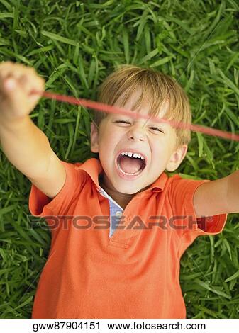 Close-up of a boy stretching a rubber band View Large Photo Image Stock Image - Close-up of a boy stretching a rubber band. Fotosearch