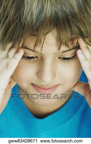 Stock Image - Close-up of a boy with his head in his hands. Fotosearch