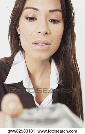 Stock Image - Close-up of a businesswoman holding American paper currency. Fotosearch