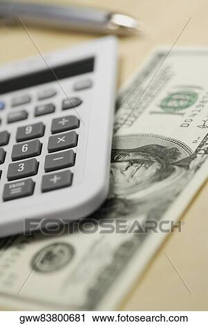 Close-up of a calculator and one hundred dollar bill on the table View Large Photo Image Stock Image - Close-up of a calculator and one hundred dollar bill on the table. Fotosearch