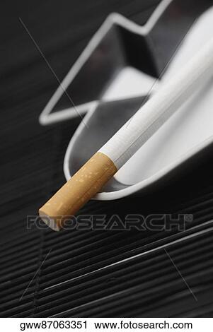 Stock Image - Close-up of a cigarette on an ashtray. Fotosearch