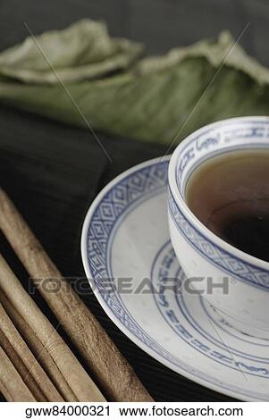 Stock Image - Close-up of a cup of coffee on a saucer with sticks beside it. Fotosearch
