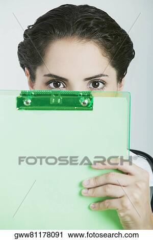 Close-up of a female doctor holding a clipboard over her face View Large Photo Image Stock Image - Close-up of a female doctor holding a clipboard over her face. Fotosearch